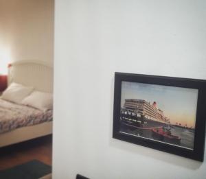 Telewizor wiszący na ścianie obok łóżka w obiekcie 616 Genova - Loft al Porto Antico w Genui