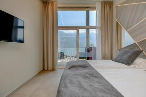 a bedroom with a bed and a large window at Hotel Du Lac in Limone sul Garda