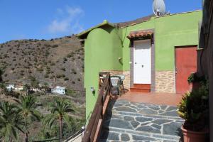 バジェエルモソにあるCasa La Hagarの白い扉と山のある緑の家