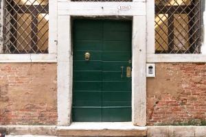 a green door on a brick building with a window at Il Pozzo Magico in Venice