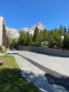 a car parked on the side of a street with mountains at Christian's apartments in Breuil-Cervinia