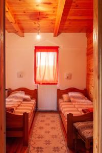 1 dormitorio con 2 camas y una ventana con cortina en Apartmani Beslic en Kremna