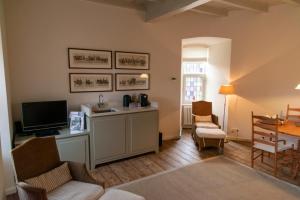 a living room with a television and a table and chairs at Kasteel Huis Bergh in s-Heerenberg