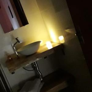 a bathroom with a sink and a counter with lights at Chalé Sonho Diniz 1 in Monte Verde