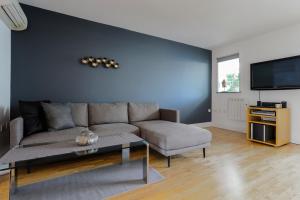 a living room with a couch and a tv at StayInn Canary Wharf in London