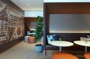a waiting room with two tables and a plant at Holiday Inn Express Sydney Airport, an IHG Hotel in Sydney