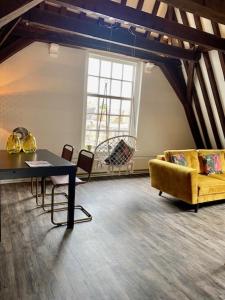 salon z żółtą kanapą i stołem w obiekcie Torenkamer Middelburgh w mieście Middelburg