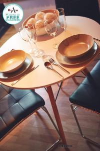 a table with plates and glasses and a basket of bread at Alcam Studio Alio3 in Barcelona