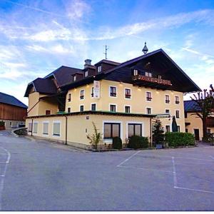 ein großes Gebäude mit einem Parkplatz davor in der Unterkunft HartlWirt Gasthof-Hotel in Salzburg