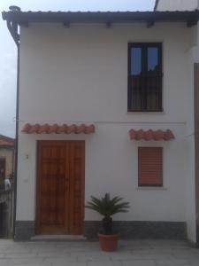 a white house with two doors and a potted plant at Galatro Terme House in Galatro