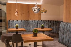 トゥクスにあるホテル ペンション ゾンライテンの鉢植えのレストランのテーブル2台と椅子