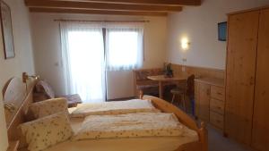 a bedroom with two beds and a table and a window at Gasthof Walde in Rifiano