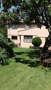 une maison avec une pelouse verte devant elle dans l'établissement The Bedford View Guest House, à Germiston