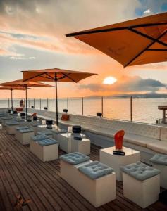 eine Reihe von Stühlen und Sonnenschirmen auf einem Pier mit dem Meer in der Unterkunft Q-Royal in Playa de Palma