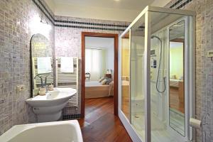 La salle de bains est pourvue d'un lavabo blanc et d'une douche. dans l'établissement Corte dei Miracoli, à Venise