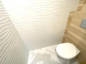 ein Bad mit einem weißen WC in einem Zimmer in der Unterkunft Центр Львова вулиця Лесі Українки 19 in Lwiw
