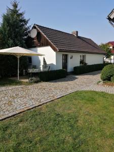 uma casa com um guarda-chuva e uma entrada de pedra em Ferienhaus Wilhelm Spreewald em Straupitz