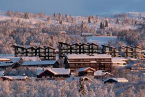 un resort in montagna con neve sui tetti di Riddertunet Leiligheter a Beitostøl
