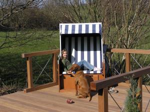 a girl sitting in a chair with a dog at De lütte im gulen Hus in Kappeln +4 photos