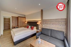 a hotel room with a bed and a couch at Hotel-Restaurant Früchtl in Zandt