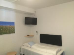 a white room with a flat screen tv on the wall at Motel Poppelvej in Herning
