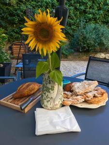 a sunflower in a vase on a table with bread at Maison Lou Roucas in Cabrières-dʼAigues
