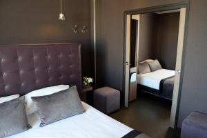 - une chambre d'hôtel avec un lit et un miroir dans l'établissement Hôtel Saint-Charles, à Paris