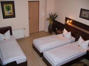 a hotel room with two beds and a hallway at Hotel Elbe Street 34 in Frankfurt +4 photos
