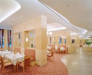 a dining room with white tables and chairs andwindows at Residenz am Dom Boardinghouse Apartments in Cologne