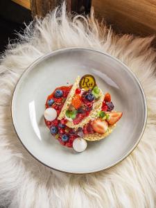 a plate with a plate of food with fruit on it at Les Rhodos in La Clusaz