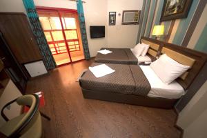 a hotel room with two beds and a window at Downtown Hotel in Dubai