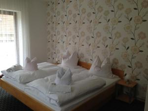 a bed with white sheets and pillows in a bedroom at Pottensteiner Stuben Pension Gasthof in Pottenstein