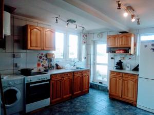 a kitchen with wooden cabinets and a white refrigerator at гостевой дом у Снежаны in Provadiya