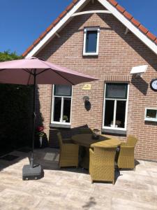 a patio with a table and chairs and an umbrella at Het Pronkje in Renesse