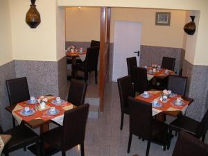 un restaurante con mesas y sillas con comida. en Hotel Elbe Street 34, en Frankfurt