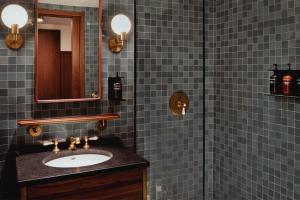 華盛頓的住宿－哥倫比亞區伊頓酒店，蓝色瓷砖浴室设有水槽和淋浴