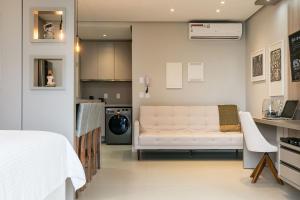 a living room with a white couch and a kitchen at Gym | Food Hall | 450m from the mall #CA04 in Florianópolis