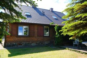 a brick house with a shingled roof at Siedlisko Egniu Agroturystyka nad jeziorem Pojezierze Drawskie in Żabinek