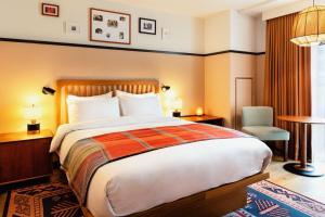 um quarto de hotel com uma cama grande e uma cadeira em Eaton DC em Washington