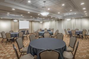 a conference room with tables and chairs and a screen at Hyatt Place College Station in College Station