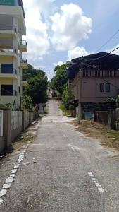 an empty street next to a tall building at Utan Teluk Nipah in Pangkor