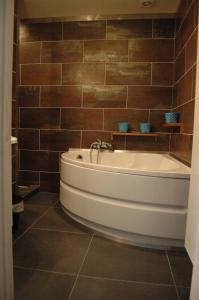 a bath tub in a bathroom with brown tiles at Holiday Home Family @ home 97 in Bruges