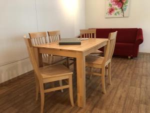 una mesa de madera con sillas y un sofá en CityApartment MELITTA, en Schladming