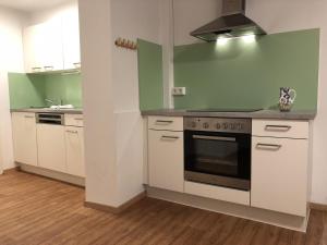 a kitchen with white cabinets and a stove top oven at CityApartment MELITTA in Schladming