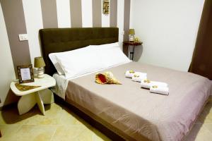 ein Bett mit zwei Handtüchern und zwei Hüten darauf in der Unterkunft Armonia Rooms in Termoli