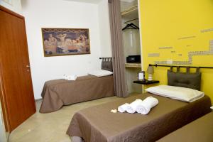 2 Betten in einem Zimmer mit gelben Wänden in der Unterkunft Armonia Rooms in Termoli