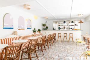 a restaurant with tables and chairs and a counter at Hôtel Le Sud in Juan-les-Pins