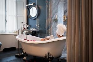 a woman in a bath tub in a bathroom at Corte Calzaiuoli Elegant Suites in Florence
