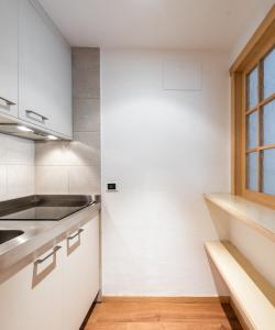 a kitchen with white cabinets and a window at Residence Antares in Selva di Val Gardena