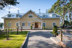 a large yellow house with a driveway at Ilola Inn in Sysmä